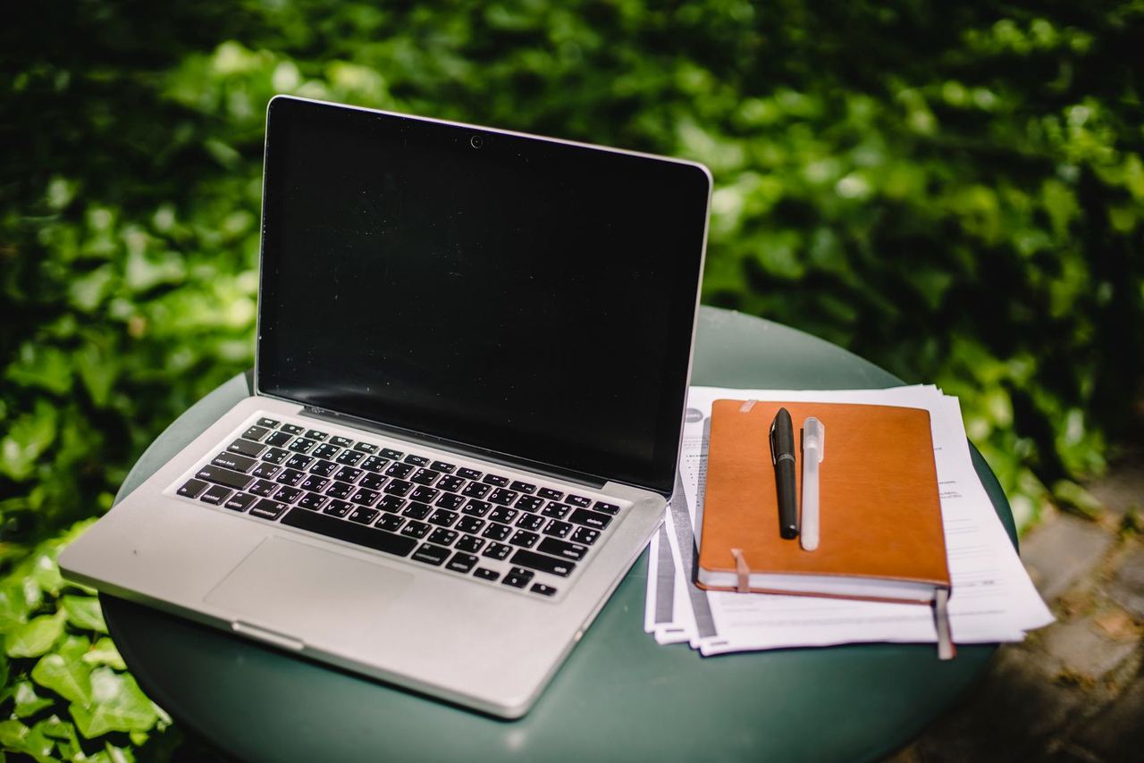 Laptop abierta junto a una libreta