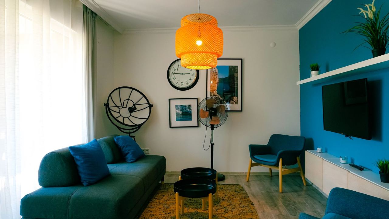 Sala de un apartamento con sofá azul y televisor