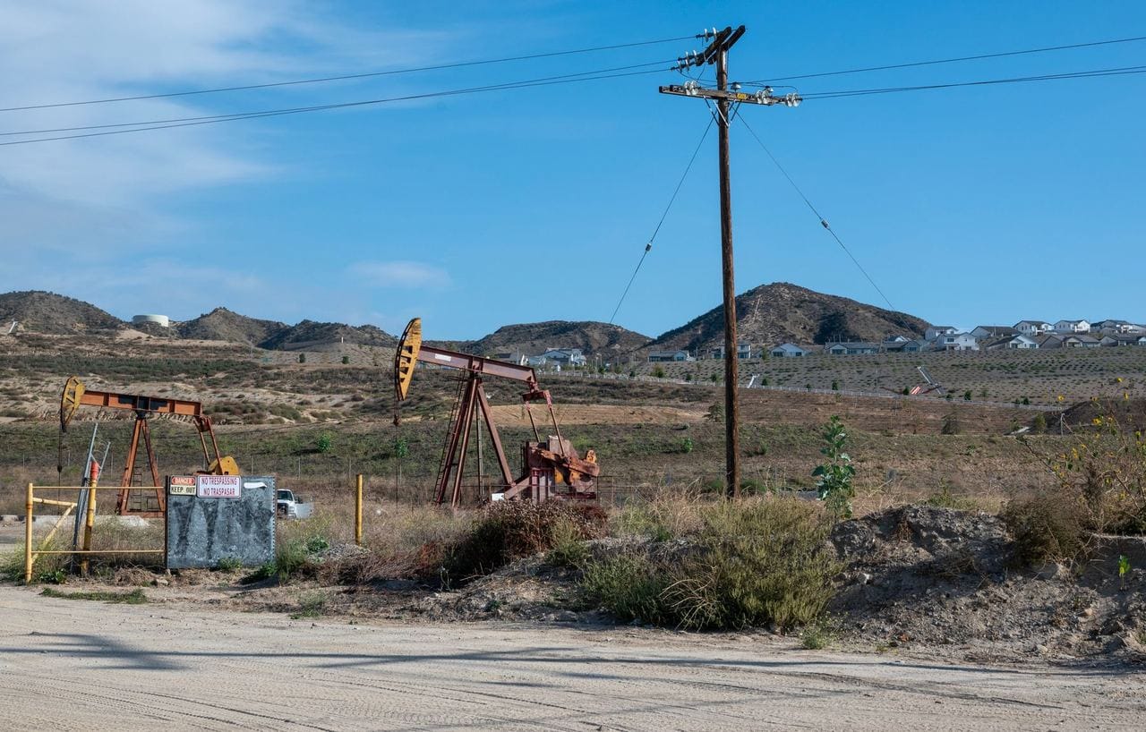 Balancines de bombeo en un campo petrolero junto a una carretera